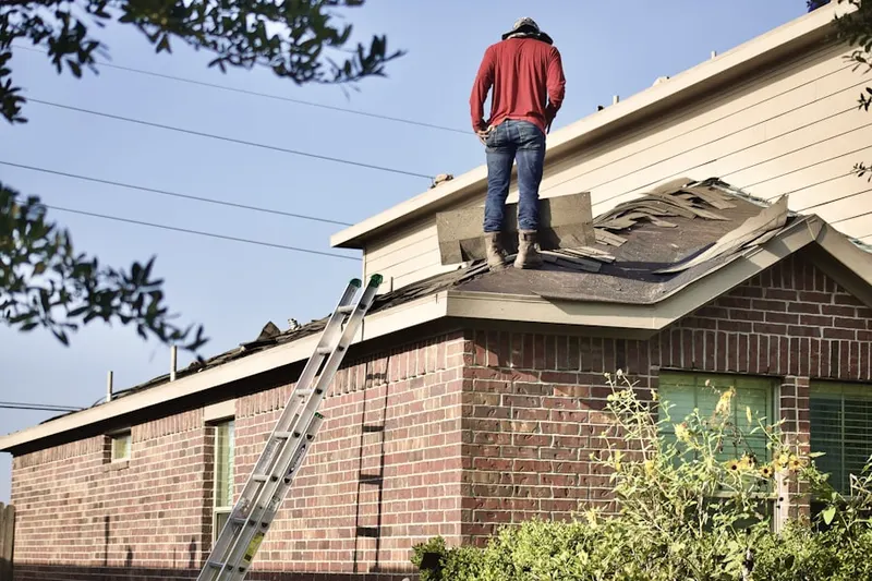 Professional roofer working on a residential roof in Holtsville